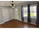 Bright living room featuring hardwood floors, large windows, and a ceiling fan at 7317 Bentley Wood Ln, Raleigh, NC 27616