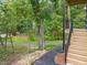 Wood staircase leading to a deck surrounded by lush trees at 100 A Masondale Ave, Durham, NC 27707