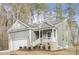 Charming one-story home featuring light green siding, a cozy front porch, and a well-manicured lawn surrounded by mature trees at 100 Sequoia Dr # 2387, Louisburg, NC 27549