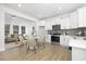 Modern kitchen flows into a cozy living area with sleek white cabinets, stainless appliances, and stylish decor at 100 Sequoia Dr # 2387, Louisburg, NC 27549