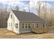 Rear exterior of a home featuring light gray siding, dark gray roof and wooden deck, set against a backdrop of trees at 100 Sequoia Dr # 2387, Louisburg, NC 27549
