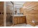 Bathroom featuring wood paneling, modern vanity, a mirror, and a tiled walk-in shower at 1018 Lakeview Dr, Cedar Grove, NC 27231