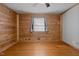 Bedroom with wood walls and hardwood floors, featuring a ceiling fan at 1018 Lakeview Dr, Cedar Grove, NC 27231