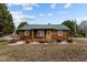 Charming log cabin with green roof, stone pathway, and landscaping at 1018 Lakeview Dr, Cedar Grove, NC 27231