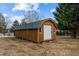 Wooden storage shed with metal roll-up door at 1018 Lakeview Dr, Cedar Grove, NC 27231