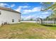 A big backyard with a storage building and trampoline, surrounded by a white fence at 108 Bonnie Girl Ct, Lillington, NC 27546