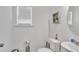Bright powder room with white walls, pedestal sink, toilet, and framed wall decor at 108 Bonnie Girl Ct, Lillington, NC 27546