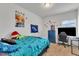 Colorful bedroom with a large window, blue dresser, and a neon 