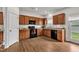 Well-lit kitchen with warm wood cabinetry, granite countertops, and modern appliances offers a welcoming space at 108 Bonnie Girl Ct, Lillington, NC 27546
