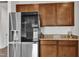 Modern kitchen features stainless steel refrigerator with granite countertops and warm wood cabinetry at 108 Bonnie Girl Ct, Lillington, NC 27546