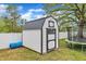 This outbuilding is white with black trim, and a dark roof. A trampoline sits nearby at 108 Bonnie Girl Ct, Lillington, NC 27546