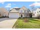 Inviting two-story home with attached garage, manicured lawn and a beautiful yellow paint at 1201 Bethpage Dr, Mebane, NC 27302