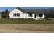White house with gray roof, landscaping, and stone accents at 148 Phil Jack Rd, Dunn, NC 28334