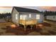 Exterior shot of the backyard and back deck of a home with light siding and dark roof at sunset at 150 Brookhaven Dr, Spring Hope, NC 27882