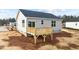 Exterior shot of the backyard and back deck of a home with light siding and dark roof at 150 Brookhaven Dr, Spring Hope, NC 27882