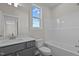 This bathroom features double sinks, gray cabinetry, and a bright window with a view of trees and a blue sky at 150 Brookhaven Dr, Spring Hope, NC 27882