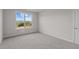 This bedroom features neutral walls, carpet, and a bright window with a view of trees and a blue sky at 150 Brookhaven Dr, Spring Hope, NC 27882