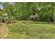 Large wooded backyard featuring a playhouse and trampoline for enjoyment and recreation at 1625 Banks View Dr, Raleigh, NC 27603