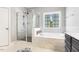Bathroom featuring a soaking tub with decorative tile surround and walk-in glass shower at 1625 Banks View Dr, Raleigh, NC 27603