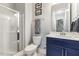 Bathroom features a glass-enclosed shower, vanity with blue cabinet, and well-lit mirror, creating a clean and functional space at 1625 Banks View Dr, Raleigh, NC 27603