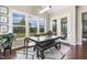 Bright dining area featuring large windows, wood floors, and a modern table with bench seating and view to yard at 1625 Banks View Dr, Raleigh, NC 27603