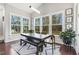 Bright dining area featuring large windows, wood floors, and a modern table with bench seating and view to yard at 1625 Banks View Dr, Raleigh, NC 27603