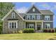 Beautiful home featuring a stone facade, covered porch, and lush landscaping creating great curb appeal at 1625 Banks View Dr, Raleigh, NC 27603