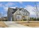 Two-story home with stone and gray siding, driveway, and basketball court at 1625 Banks View Dr, Raleigh, NC 27603