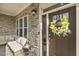 Inviting front door with stone facade, cozy seating, and a cheerful wreath, creating a welcoming entrance at 1625 Banks View Dr, Raleigh, NC 27603