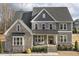 Charming home featuring stone accents, a welcoming front porch with seating, and manicured landscaping at 1625 Banks View Dr, Raleigh, NC 27603