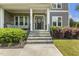 Inviting front porch with stone steps, black railing, and a cozy seating area for relaxing at 1625 Banks View Dr, Raleigh, NC 27603