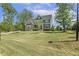 Spacious front yard with a lush lawn, mature trees, and a view of the lovely home at 1625 Banks View Dr, Raleigh, NC 27603