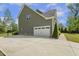 Exterior view of the home's side showing the attached garage with a concrete driveway and landscaped yard at 1625 Banks View Dr, Raleigh, NC 27603