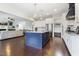 Open concept kitchen with a navy island, stainless appliances, and a seamless view into the living room at 1625 Banks View Dr, Raleigh, NC 27603