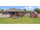 Backyard view featuring red storage shed, patio, and screened porch at 2001 Bunnfield Dr, Zebulon, NC 27597
