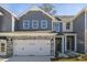 Gray townhome with stone accents, two-car garage, and landscaping at 2328 Sugar Cone Way, Fuquay Varina, NC 27526