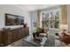 Spacious living room with large windows, comfortable seating, and a media cabinet at 2334 Sugar Cone Way, Fuquay Varina, NC 27526