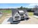 Expansive aerial view of a modern farmhouse-style home with ample yard space in a lush, green neighborhood at 321 Bud Wall Rd, Youngsville, NC 27596