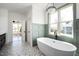 Bright bathroom features a freestanding tub next to a large window with stylish, modern fixtures at 321 Bud Wall Rd, Youngsville, NC 27596