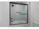 Bathroom with a modern glass-enclosed shower with sleek black hardware and marble-look tiles at 321 Bud Wall Rd, Youngsville, NC 27596
