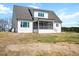 Rear exterior view of home with white siding, screened in porch, a patio, and large backyard at 321 Bud Wall Rd, Youngsville, NC 27596