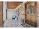 Inviting front porch with brick floor, sitting area, wood ceiling, and natural wood door at 321 Bud Wall Rd, Youngsville, NC 27596