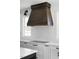 Close-up of a modern kitchen with stainless steel appliances and a custom range hood at 321 Bud Wall Rd, Youngsville, NC 27596