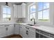 Bright kitchen with white cabinets, stainless steel appliances, and large windows allowing natural light at 321 Bud Wall Rd, Youngsville, NC 27596