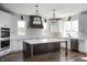 Modern kitchen featuring a large island, white cabinets, stainless steel appliances, and custom lighting at 321 Bud Wall Rd, Youngsville, NC 27596