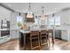 Modern kitchen with island seating, stainless steel appliances, and sleek white cabinetry at 321 Bud Wall Rd, Youngsville, NC 27596