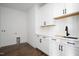 Bright laundry room with white shaker cabinets, quartz countertops and modern fixtures at 321 Bud Wall Rd, Youngsville, NC 27596