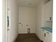 Unfinished laundry room with white cabinets, ample space, and a dark stained floor at 321 Bud Wall Rd, Youngsville, NC 27596