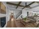Open-concept living room boasts exposed wood beams, fireplace, and seamless flow to the entry at 321 Bud Wall Rd, Youngsville, NC 27596