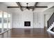 Bright living room featuring a fireplace with built-in shelving, wood floors, and beamed ceilings at 321 Bud Wall Rd, Youngsville, NC 27596